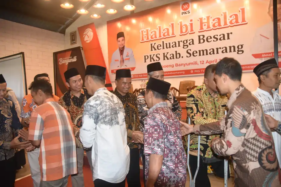 Sejumlah kader PKS Kabupaten Semarang berjabat tangan dan saling bersalaman dalam acara Halal Bihalal di Kampoeng Banyumili. Semua peserta mengenakan berbagai motif batik Nusantara dan beberapa mengenakan peci atau kopiah, dengan latar belakang panggung bertuliskan “Halal bi Halal Keluarga Besar PKS Kab. Semarang” dan foto Muhammad Nurkholis serta Ahmad Muntaha.