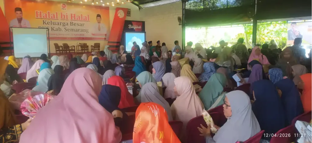 Ratusan peserta berhijab duduk di aula mengikuti acara Halal Bihalal PKS Kabupaten Semarang, terlihat ramai membuka kado dan tersenyum.